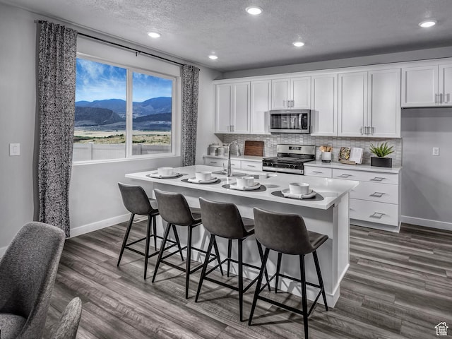 424 W 630 N Unit 0005, Tooele, UT 84074 - kitchen with appliances with stainless steel finishes, baseboards, a sink, decorative backsplash, and a textured ceiling