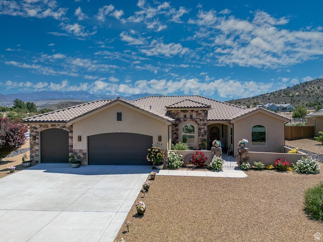 814 N High Ground Dr, Dammeron Valley, UT 84783 - mediterranean / spanish-style home featuring stucco siding, a garage, a mountain view, and concrete driveway