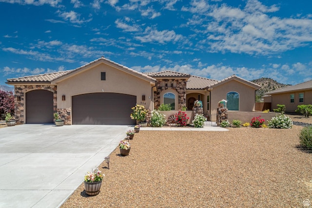 814 N High Ground Dr, Dammeron Valley, UT 84783 - mediterranean / spanish-style house featuring a garage, stucco siding, a tile roof, and driveway
