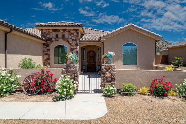 814 N High Ground Dr, Dammeron Valley, UT 84783 - mediterranean / spanish home featuring a gate, a tiled roof, stucco siding, and a fenced front yard