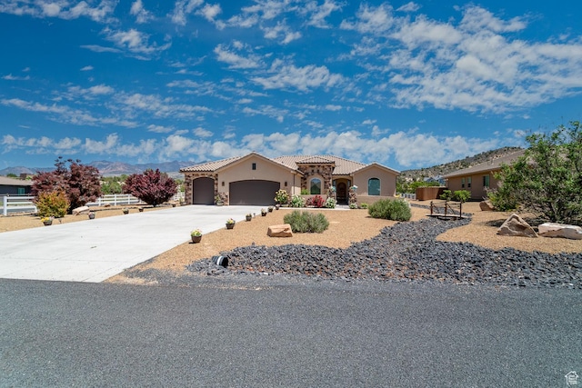 814 N High Ground Dr, Dammeron Valley, UT 84783 - mediterranean / spanish home with a tiled roof, an attached garage, stucco siding, concrete driveway, and a mountain view