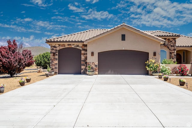 814 N High Ground Dr, Dammeron Valley, UT 84783 - mediterranean / spanish-style home with a tiled roof, an attached garage, stucco siding, and a mountain view