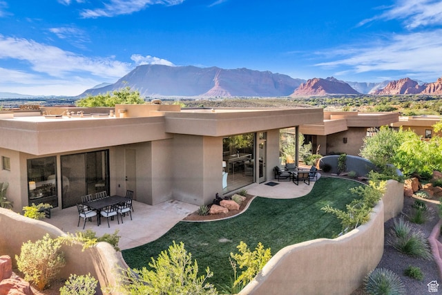 2549 W Sinagua Trl Unit 26, St George, UT 84770 - back of house featuring a mountain view, stucco siding, a patio, and a lawn
