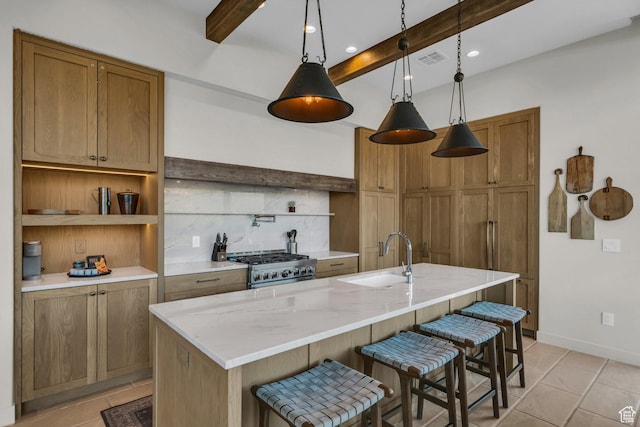 2549 W Sinagua Trl Unit 26, St George, UT 84770 - kitchen featuring a sink, stainless steel range with gas stovetop, beamed ceiling, backsplash, and a kitchen bar