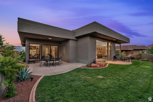 2549 W Sinagua Trl Unit 26, St George, UT 84770 - back of property with stucco siding, a patio, and a lawn
