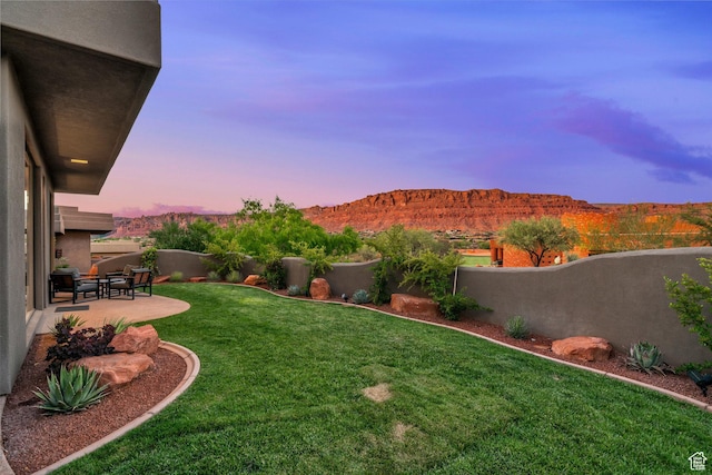 2549 W Sinagua Trl Unit 26, St George, UT 84770 - yard at dusk with a patio and a mountain view