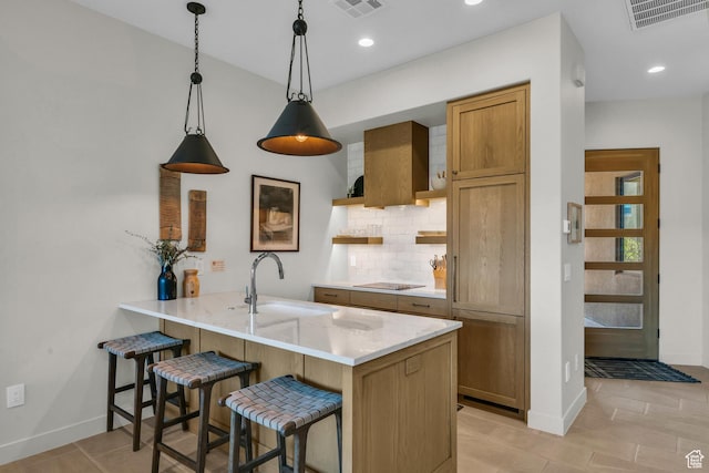 2549 W Sinagua Trl Unit 26, St George, UT 84770 - kitchen featuring a sink, backsplash, baseboards, a breakfast bar area, and recessed lighting
