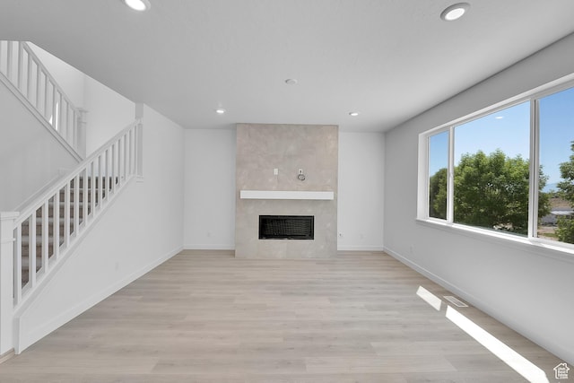 127 E Heron Ave Unit 808, Saratoga Springs, UT 84045 - unfurnished living room with stairs, recessed lighting, a fireplace, light wood finished floors, and baseboards