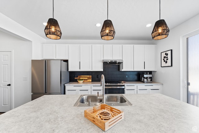 47 E Broxburn Way N, Tooele, UT 84074 - kitchen with stainless steel appliances, under cabinet range hood, a sink, hanging light fixtures, and recessed lighting