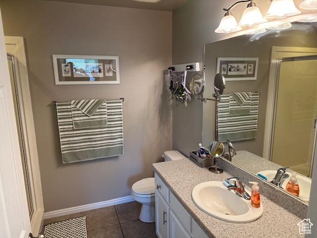2025 E Skyline Dr, South Ogden, UT 84403 - bathroom with vanity, a stall shower, toilet, baseboards, and tile patterned floors