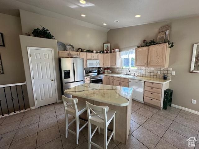 2025 E Skyline Dr, South Ogden, UT 84403 - kitchen with appliances with stainless steel finishes, light brown cabinetry, light countertops, decorative backsplash, and light tile patterned floors