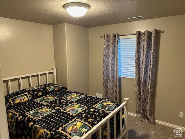 2025 E Skyline Dr, South Ogden, UT 84403 - carpeted bedroom featuring a textured ceiling and baseboards