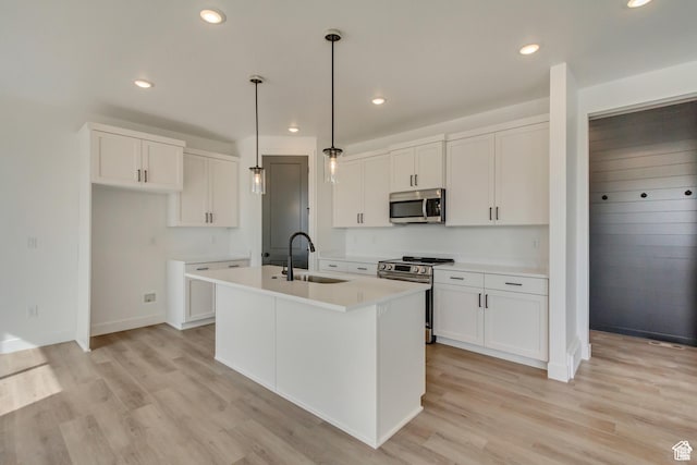 1471 E 1400 N Unit 55, Payson, UT 84651 - kitchen featuring appliances with stainless steel finishes, a sink, light wood-type flooring, an island with sink, and recessed lighting