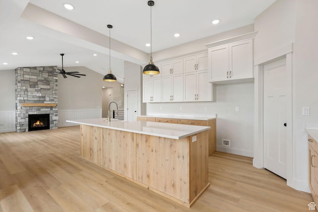 2409 W 3000 N, Farr West, UT 84404 - kitchen with ceiling fan, wainscoting, light wood-style floors, an island with sink, and light countertops