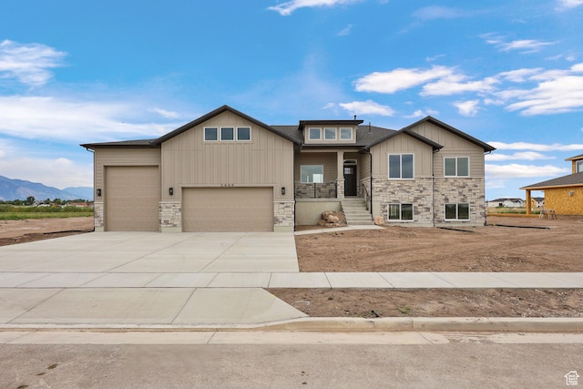 2409 W 3000 N, Farr West, UT 84404 - craftsman house featuring stone siding, a garage, concrete driveway, board and batten siding, and a mountain view