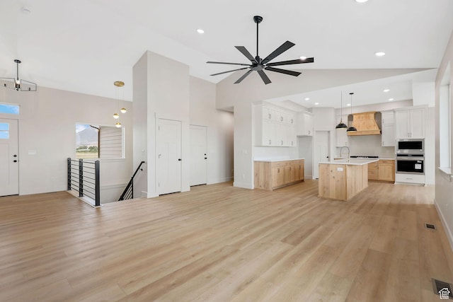 2409 W 3000 N, Farr West, UT 84404 - unfurnished living room with light wood finished floors, high vaulted ceiling, and a ceiling fan