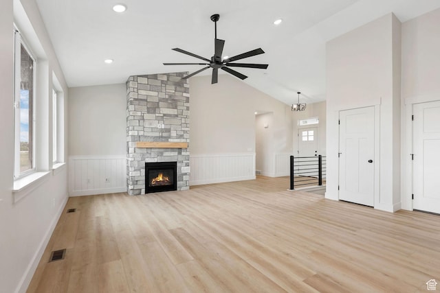 2409 W 3000 N, Farr West, UT 84404 - unfurnished living room featuring vaulted ceiling, a ceiling fan, a wainscoted wall, light wood finished floors, and a fireplace