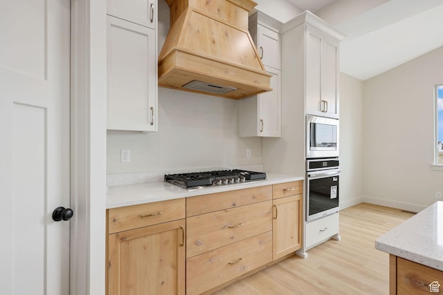 2409 W 3000 N, Farr West, UT 84404 - kitchen with appliances with stainless steel finishes, custom exhaust hood, light wood-type flooring, and light stone countertops