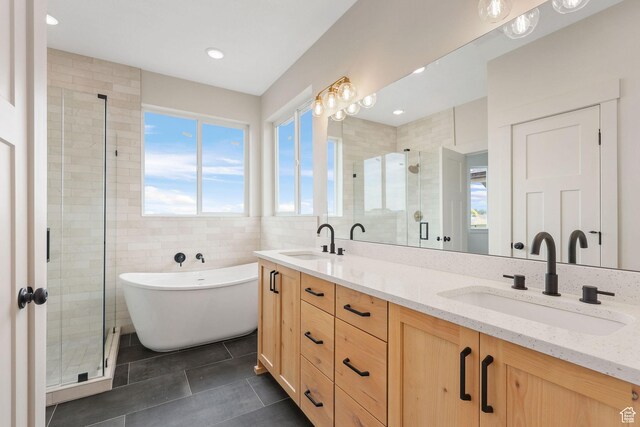 2409 W 3000 N, Farr West, UT 84404 - bathroom featuring tile patterned flooring, a stall shower, double vanity, a freestanding bath, and tile walls