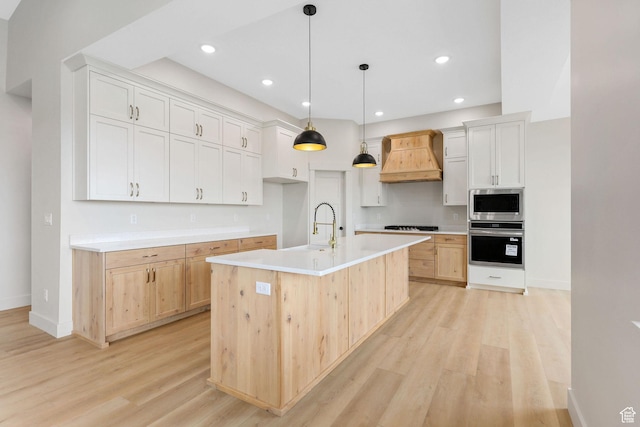 2409 W 3000 N, Farr West, UT 84404 - kitchen featuring stainless steel appliances, custom exhaust hood, light wood-style floors, light countertops, and a kitchen island with sink