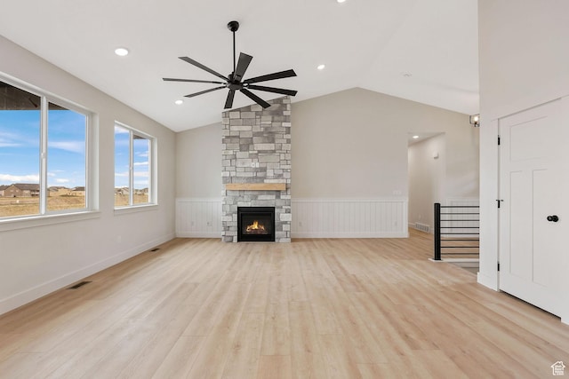 2409 W 3000 N, Farr West, UT 84404 - unfurnished living room featuring a ceiling fan, light wood-style flooring, a wainscoted wall, vaulted ceiling, and a fireplace