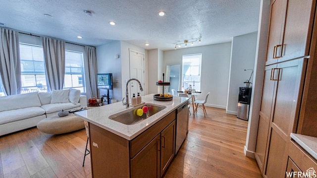 6654 W Skip Rock Rd S, South Jordan, UT 84009 - kitchen with a sink, a kitchen breakfast bar, light wood finished floors, healthy amount of natural light, and a textured ceiling