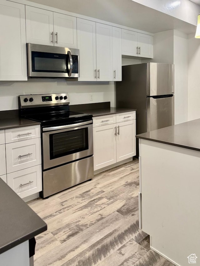 875 S Depot St Unit C211, Clearfield, UT 84015 - kitchen featuring stainless steel appliances, dark countertops, and white cabinetry
