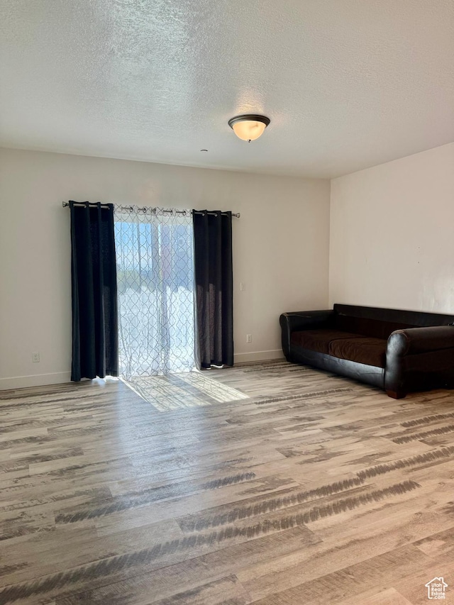 875 S Depot St Unit C211, Clearfield, UT 84015 - living room featuring wood finished floors, baseboards, and a textured ceiling
