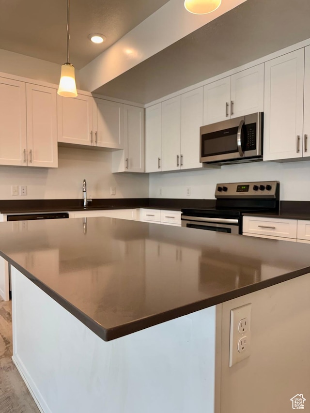 875 S Depot St Unit C211, Clearfield, UT 84015 - kitchen with appliances with stainless steel finishes, dark countertops, white cabinets, a center island, and recessed lighting