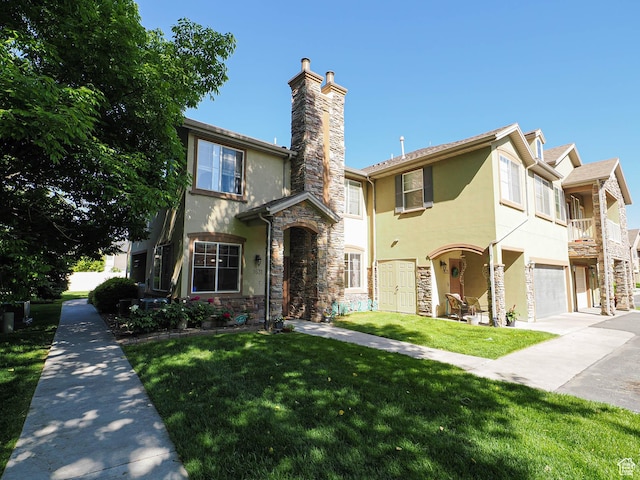 1631 W 50 N, Pleasant Grove, UT 84062 - view of front facade with stucco siding, a chimney, stone siding, a garage, and a front lawn