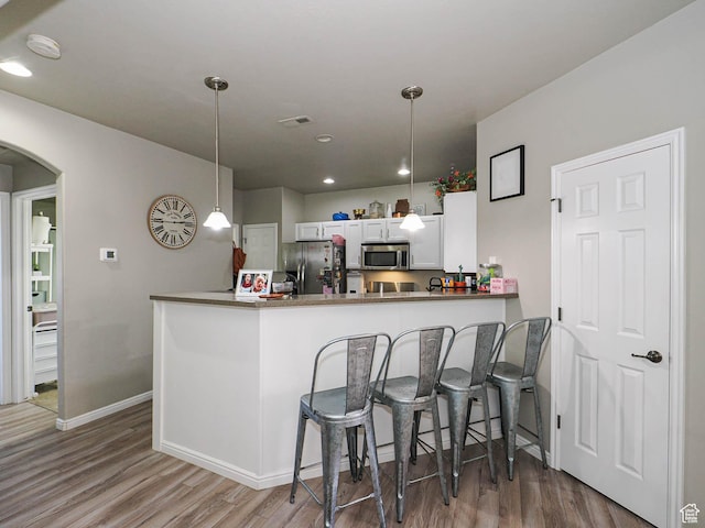 1631 W 50 N, Pleasant Grove, UT 84062 - kitchen with appliances with stainless steel finishes, wood finished floors, arched walkways, baseboards, and decorative light fixtures