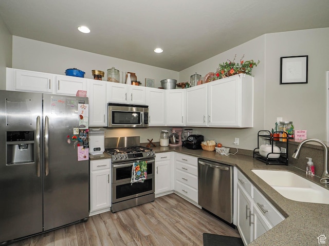 1631 W 50 N, Pleasant Grove, UT 84062 - kitchen with appliances with stainless steel finishes, a sink, white cabinets, light wood finished floors, and recessed lighting