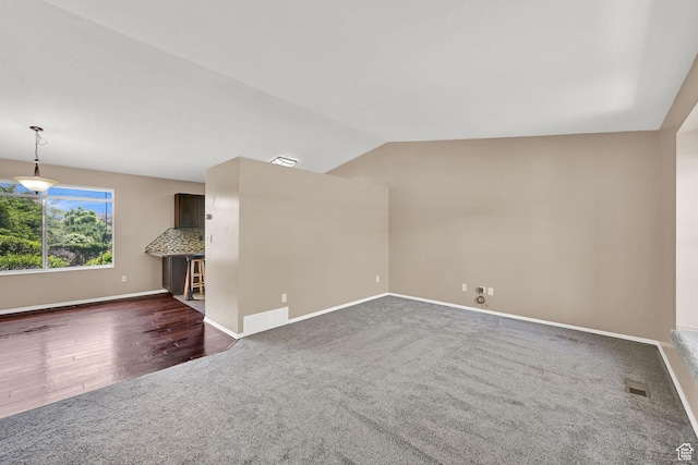639 W 3750 S, Riverdale, UT 84405 - unfurnished living room featuring dark carpet, vaulted ceiling, and baseboards