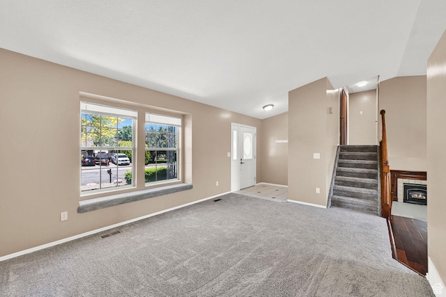 639 W 3750 S, Riverdale, UT 84405 - unfurnished living room with baseboards, stairway, vaulted ceiling, and carpet floors
