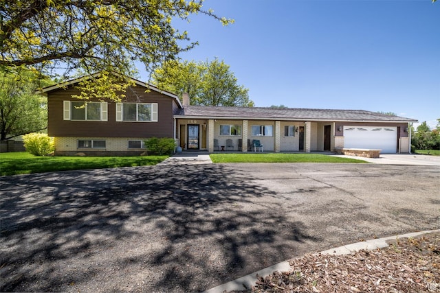 550 S 1500 W, Vernal, UT 84078 - split level home with concrete driveway, an attached garage, brick siding, a chimney, and a front lawn