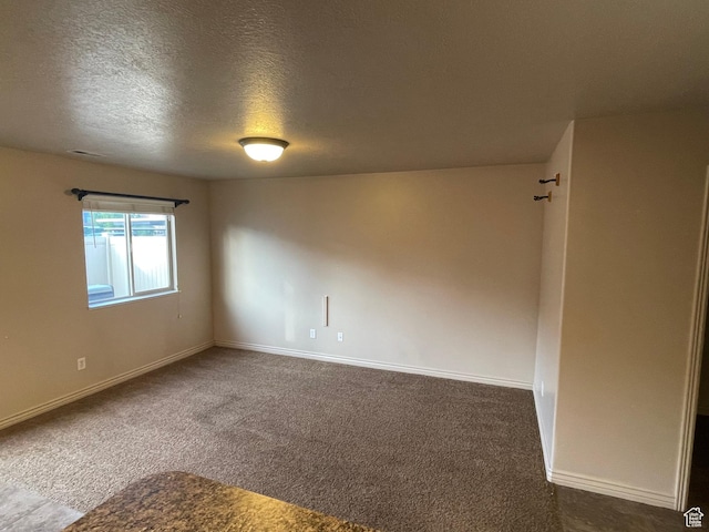 1126 W Lancelot Ln, West Haven, UT 84401 - unfurnished room featuring dark colored carpet, baseboards, and a textured ceiling