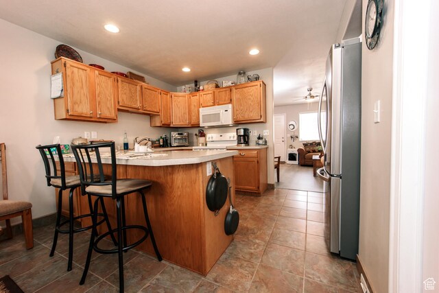 1969 N 275 W, Harrisville, UT 84414 - kitchen featuring white microwave, freestanding refrigerator, stove, a peninsula, and light countertops