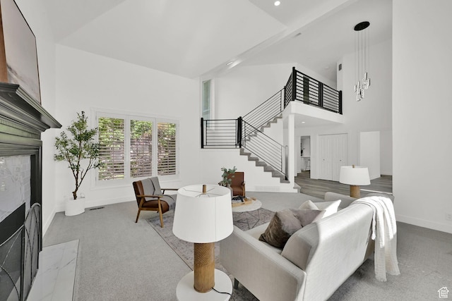 4781 Canterbury Rd, South Ogden, UT 84403 - living area with a fireplace with flush hearth, stairs, a towering ceiling, baseboards, and carpet