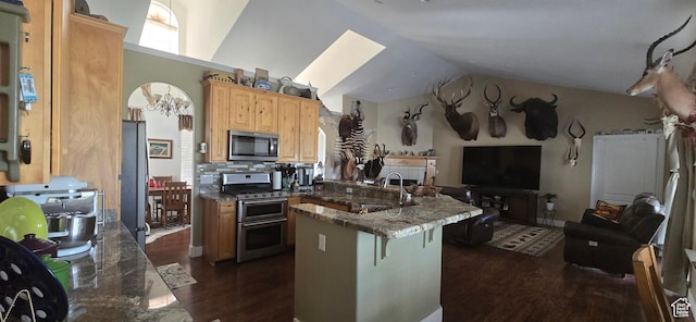 6897 S 4000 W, Benjamin, UT 84660 - kitchen with appliances with stainless steel finishes, a peninsula, a sink, dark wood-style floors, and a kitchen bar