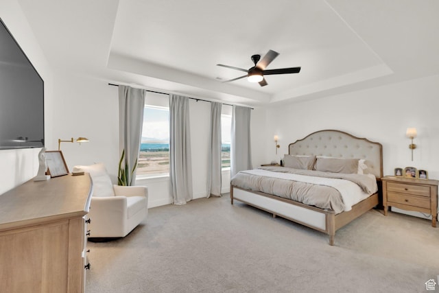 12297 S Boggs Way, Herriman, UT 84096 - bedroom featuring a tray ceiling, light carpet, and a ceiling fan