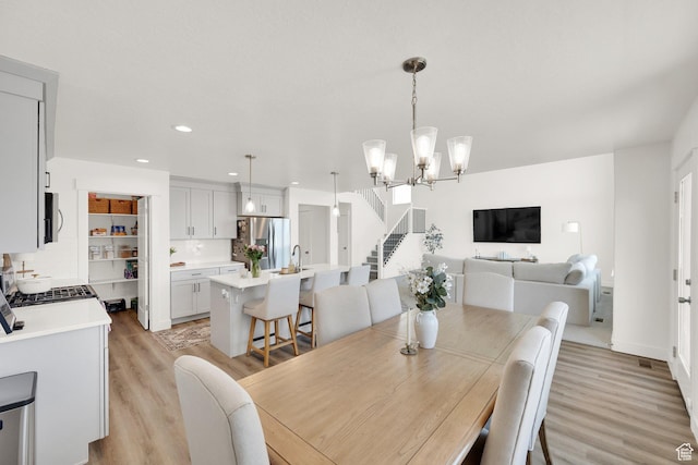 12297 S Boggs Way, Herriman, UT 84096 - dining room featuring light wood-style flooring, recessed lighting, a chandelier, and stairs