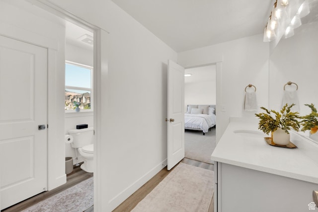 12297 S Boggs Way, Herriman, UT 84096 - ensuite bathroom featuring vanity, toilet, wood finished floors, and baseboards