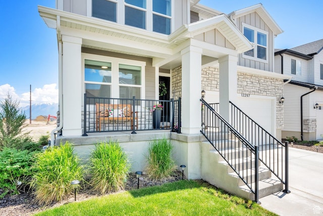12297 S Boggs Way, Herriman, UT 84096 - view of front of property featuring an attached garage, concrete driveway, a porch, stone siding, and board and batten siding