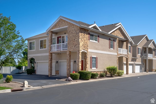 1052 S Canyon Meadows Dr Unit 4, Provo, UT 84606 - townhome / multi-family property with stone siding, a balcony, stucco siding, and a garage
