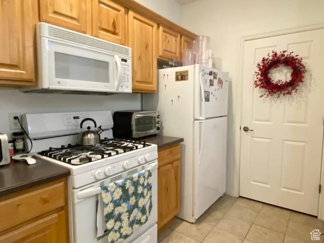 1052 S Canyon Meadows Dr Unit 4, Provo, UT 84606 - kitchen with white appliances, dark countertops, and light tile patterned floors