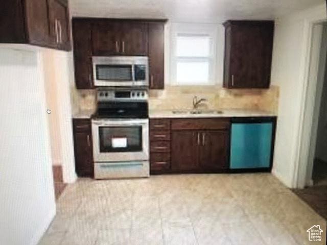1419 S Grant, Ogden, UT 84404 - kitchen featuring appliances with stainless steel finishes, light countertops, a sink, dark brown cabinetry, and tasteful backsplash