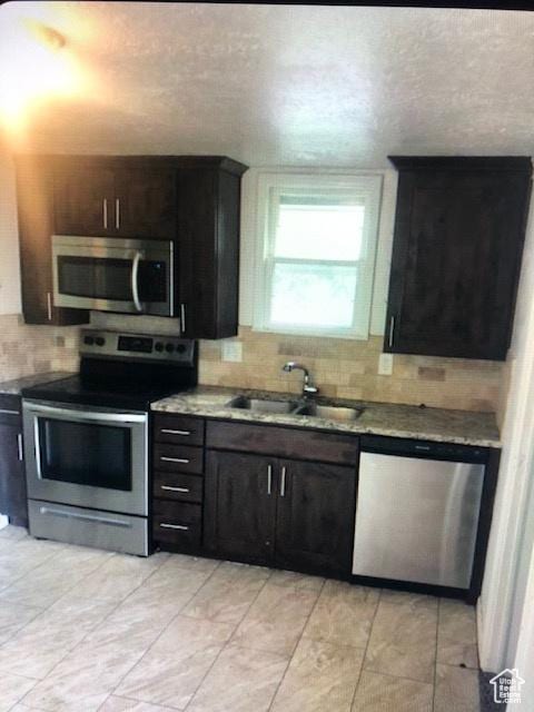 1419 S Grant, Ogden, UT 84404 - kitchen featuring stainless steel appliances, a sink, tasteful backsplash, and a textured ceiling