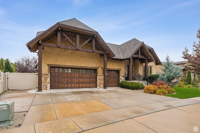 5964 S Ragsdale Dr E, Murray, UT 84121 - view of front of home featuring stone siding, stucco siding, concrete driveway, an attached garage, and a gate