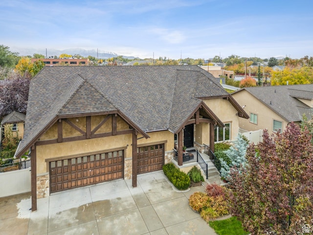 5964 S Ragsdale Dr E, Murray, UT 84121 - view of front facade featuring a shingled roof, stone siding, stucco siding, concrete driveway, and an attached garage