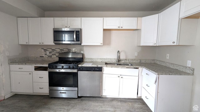4650 W Mildred St, Kearns, UT 84118 - kitchen with stainless steel appliances, a sink, white cabinets, and light wood-style floors